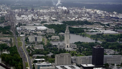 The Louisiana state capitol with an ExxonMobil refinery in the distance.